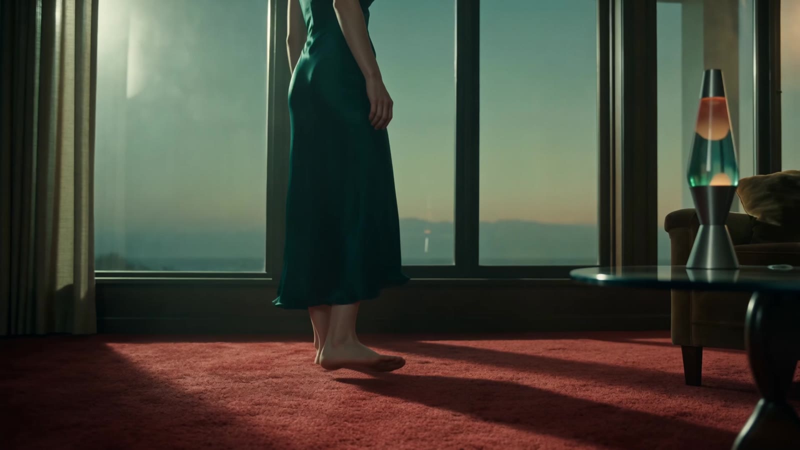 The woman standing at the window of a red-carpeted room
